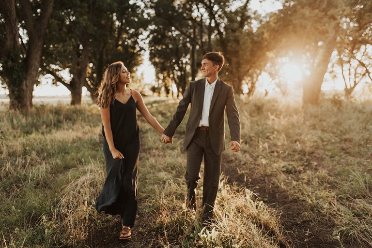 engagement session at sunset a couple holding hands and walking