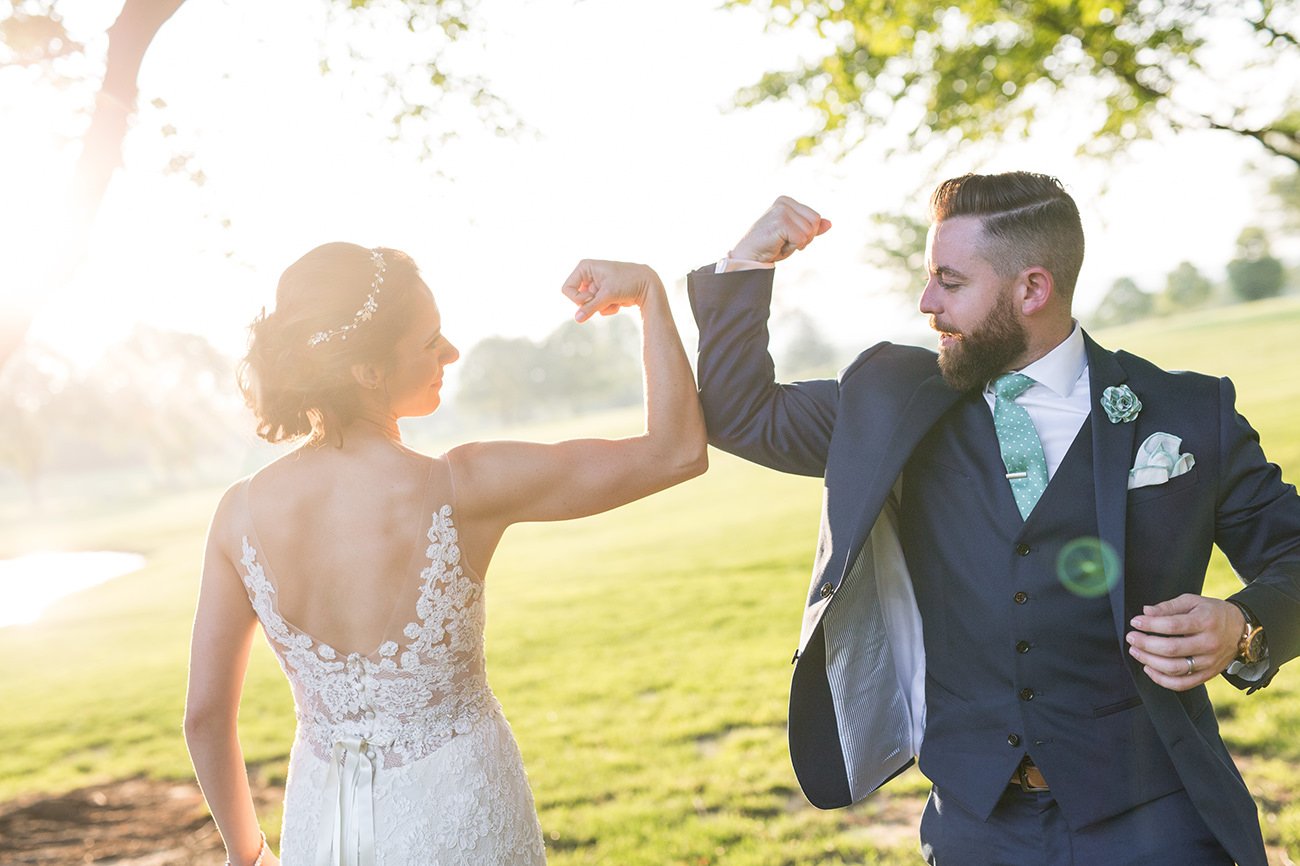 A bride and groom making muscles to show off who did better at the he said she said bridal shower game.