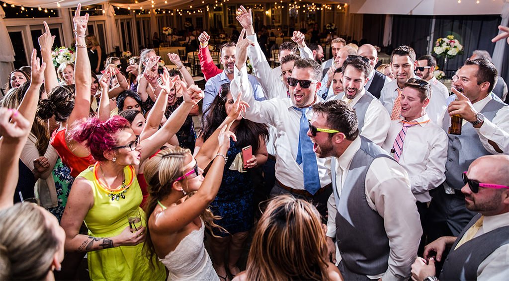 wedding guests dancing to the best wedding reception dance songs on the dance floor.