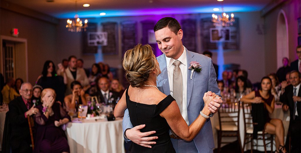 A mother dancing with her son at the wedding reception. they are dancing to their favorite songs.