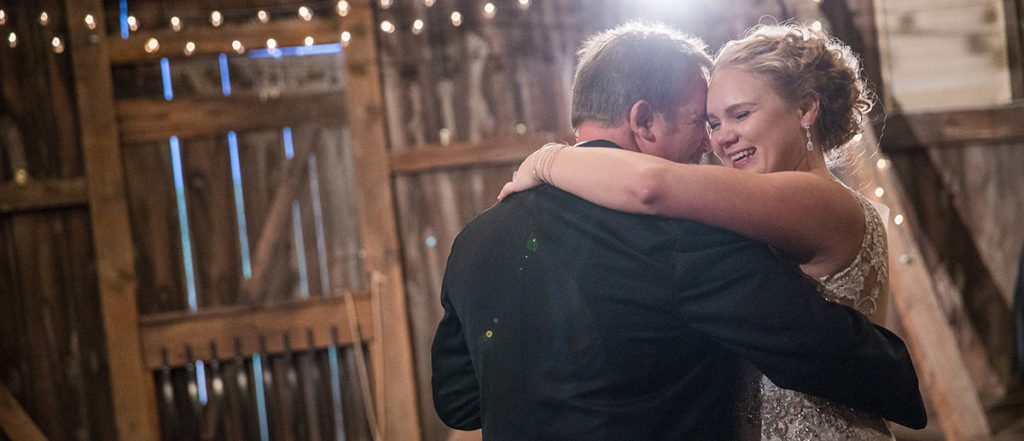 A bride and her dad doing the father daughter dance at a wedding reception. They are dancing to a Frank Sinatra song