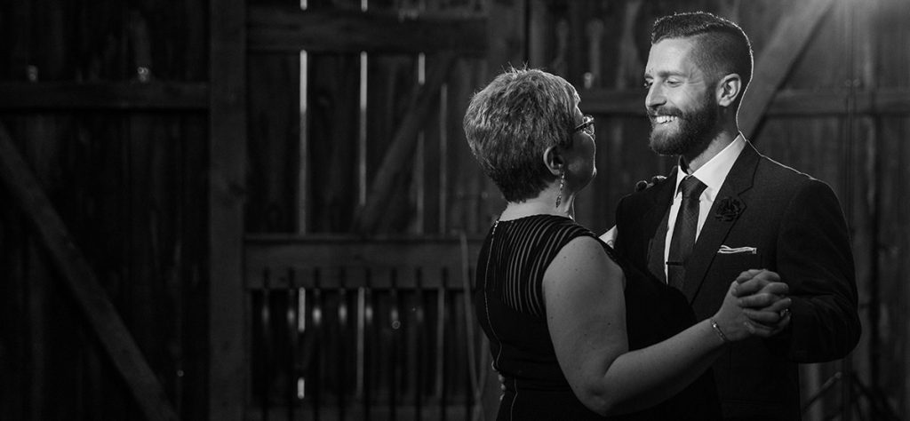 A mother of the groom and her son doing a dance at the wedding reception. They are dancing to a Frank Sinatra song.