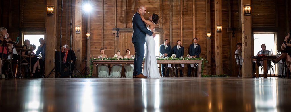 A bride and groom dancing their first dance at a wedding reception.