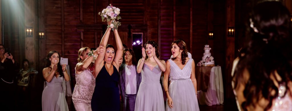 A group of girls trying to catch the bouquet after the bride tossed it
