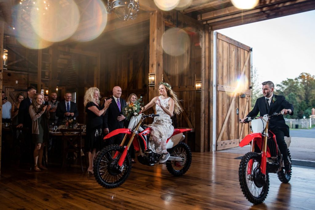 A bride and groom arriving to the wedding reception on Honda dirt bikes