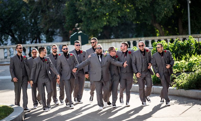 a groom and groomsmen walking down the street