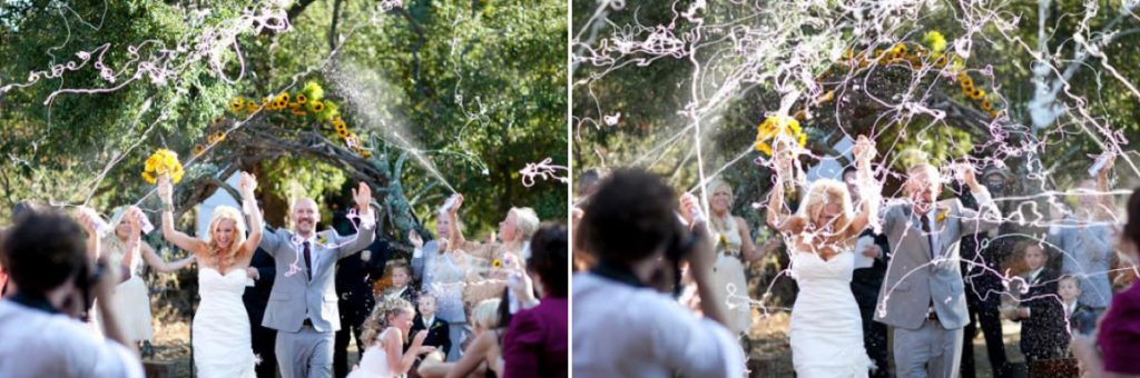 A bride and groom walking down the aisle for the ceremony exit and guests are spraying silly string on them