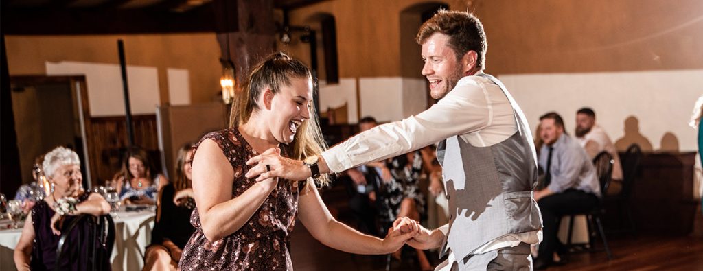 A groom dancing with his sister at the wedding reception. they are dancing to the groom's favorite song.
