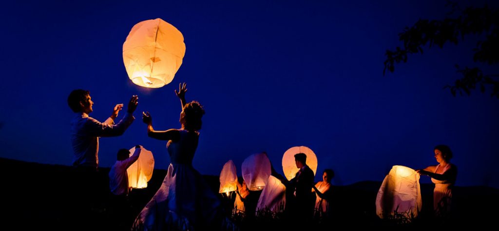 A wedding couple doing a sky lantern send off after their wedding reception