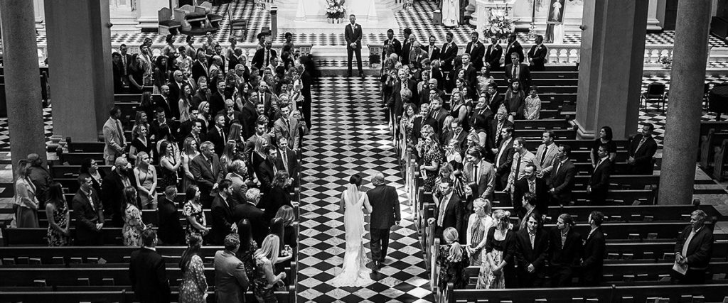 The bridal wedding ceremony processional to a great song. This photo is taken from above of the bride and her father walking down the aisle.