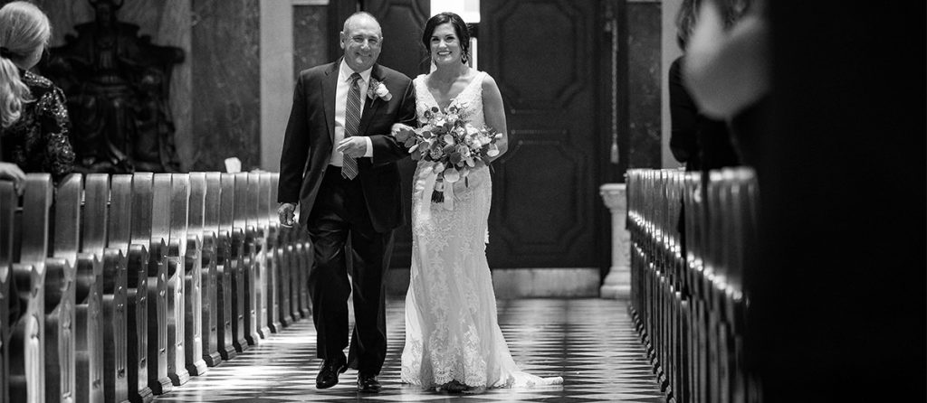 A bride and her dad walking down the aisle at the wedding ceremony