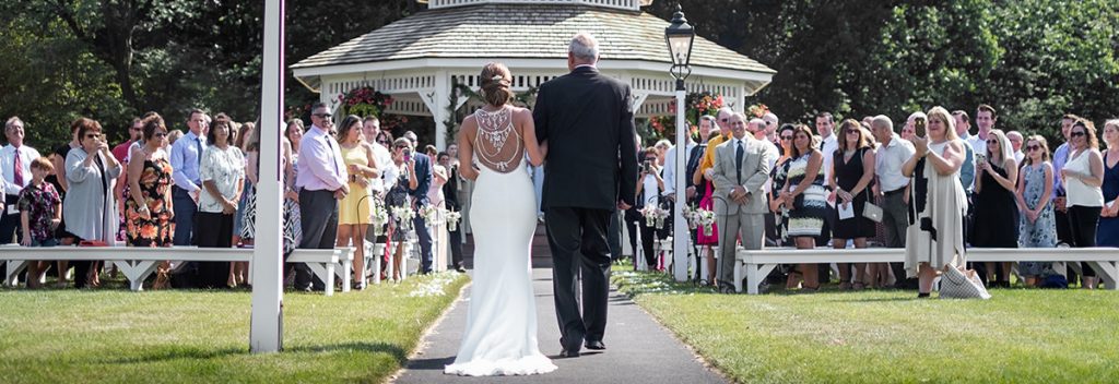 A photo taken from the back of the bride walking into the ceremony to an amazing song. This part of the wedding is called the processional