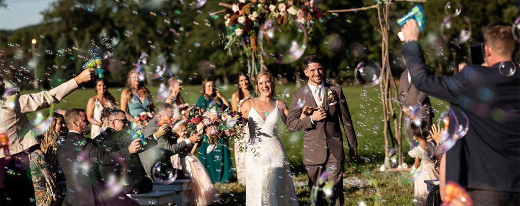 The bride and groom leaving the ceremony with bubbles. A wedding photography must have photo for the shot list.