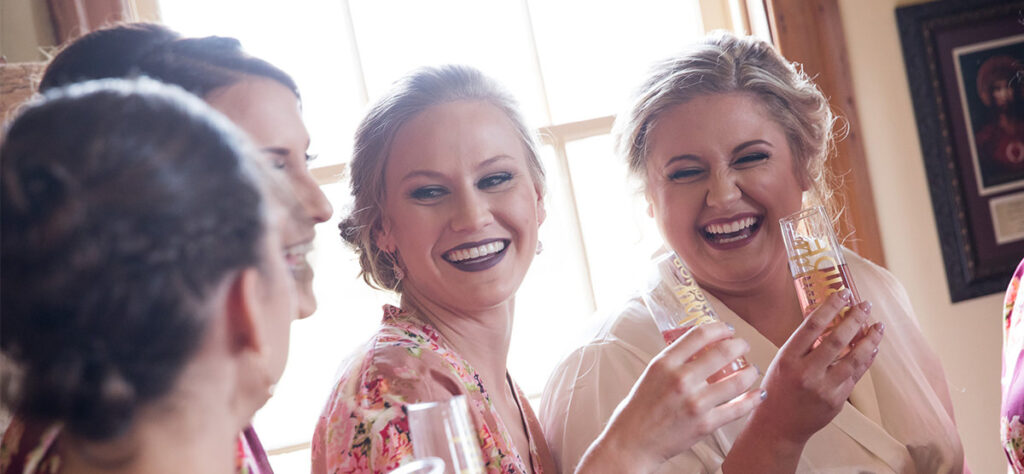 A bride having a champagne toast with her bridesmaids. This is on of the photos that should be included in your wedding photography shot list.