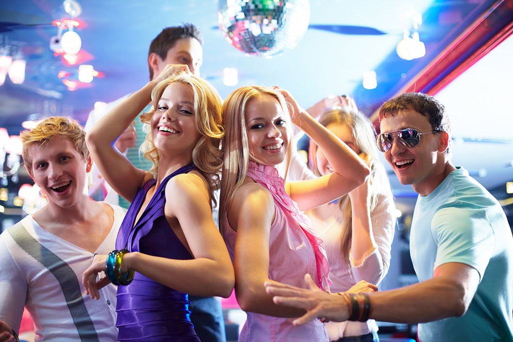 A group of people dancing on the dance floor at a wedding. This is for the article, best 80s wedding dance songs.