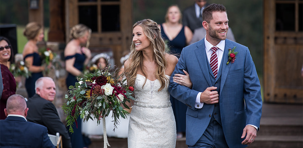 A bride and groom walking down the aisle after their wedding ceremony. This is for the article called best wedding ceremony recessional songs.