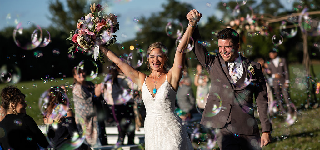 A bride and groom doing a bubble exit at their wedding. This is for the article called wedding ceremony recessional songs.