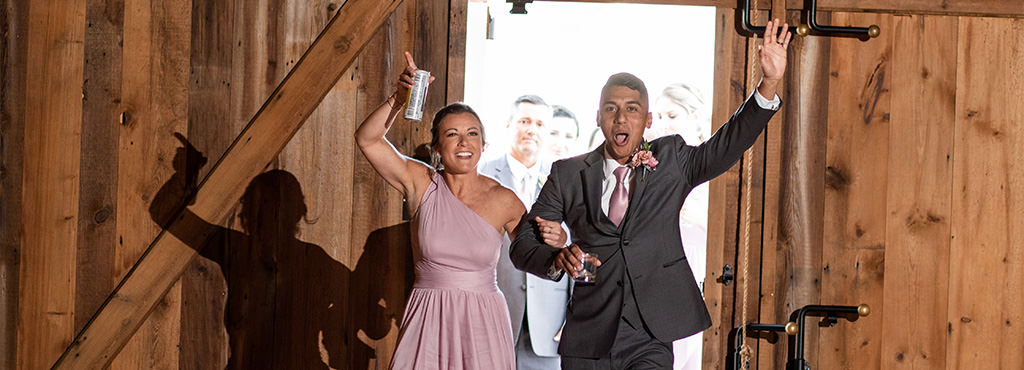 A bridesmaid and best man entering the wedding reception to a fun song