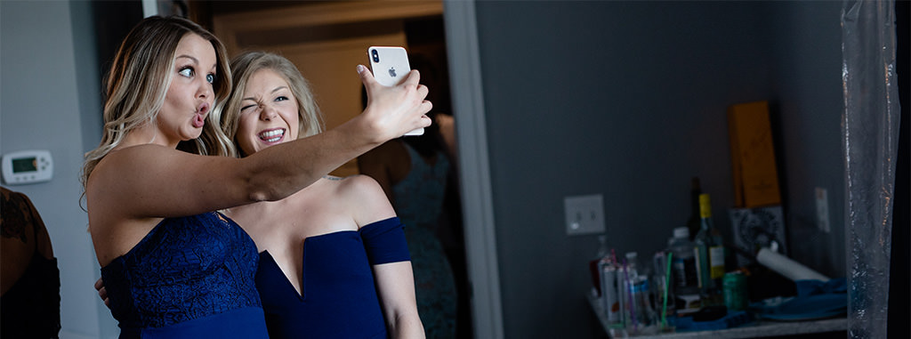 Bridesmaids making faces while taking a selfie at a wedding. This is for the article called wedding quotes and captions for instagram.