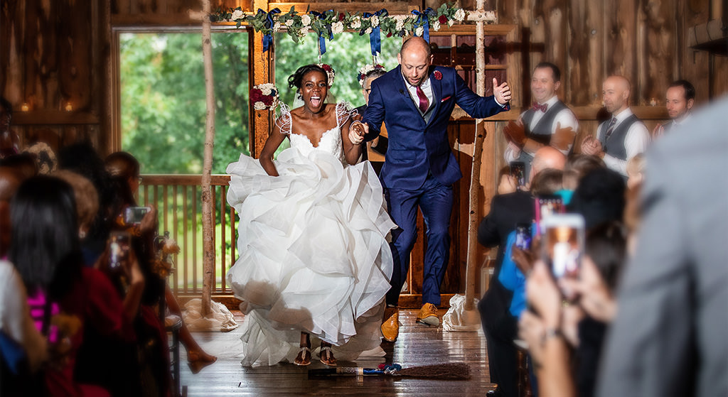 A bride and groom junping the brook at their wedding ceremony