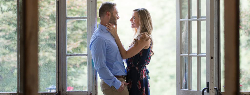 A girl looking into the eyes of a man while standing in a doorway.