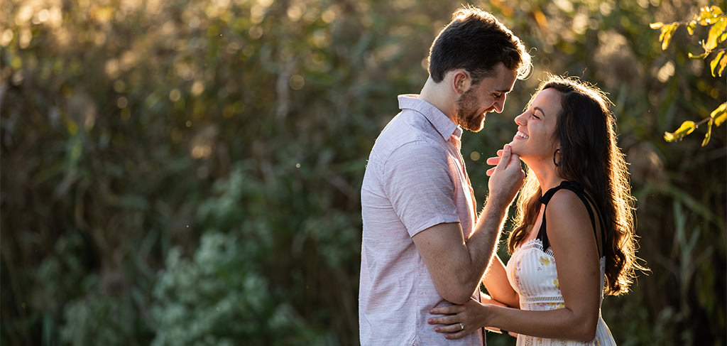A man with his hands on the chin of a woman just before they kiss