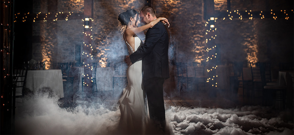 A guy and girl slow dancing to romantic music. There is fog on the ground. This is for the article Love Songs for Him.