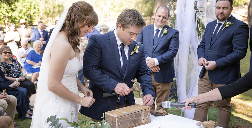 A bride and groom doing a time capsule unity ceremony at their wedding