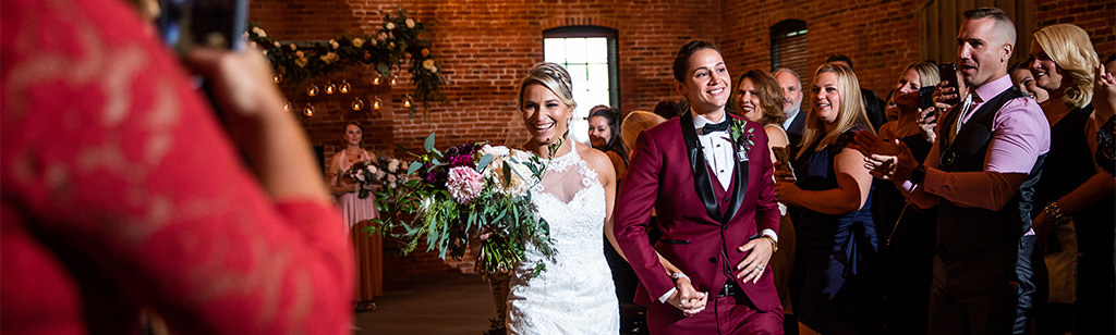 Two brides walking down the aisle after their wedding ceremony.