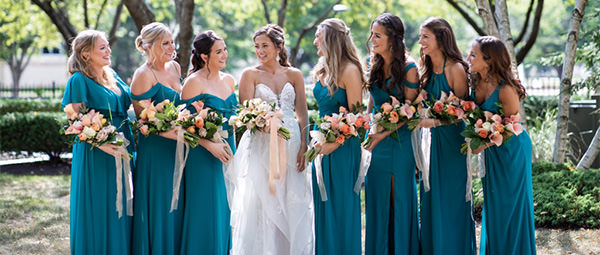 A bride and bridesmaids looking at each other and laughing. This is the cover photo for the article called bridesmaid captions for Instagram.