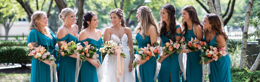 A bride and bridesmaids looking at each other and laughing. This is for the article called bridesmaid captions for Instagram photos
