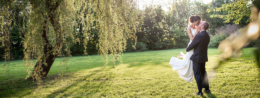A groom picking up a bride and kissing her. This is for the article called bridal shower jeopardy.