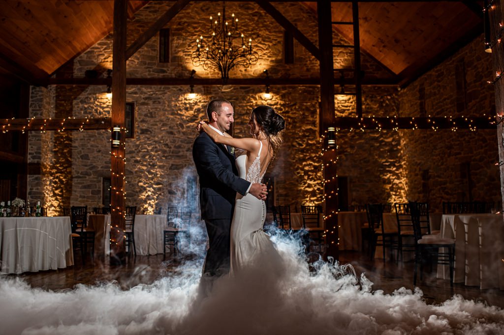 A bride and groom doing a private last dance at their wedding reception. They used a smoke machine so there is fog rising up from the dance floor.