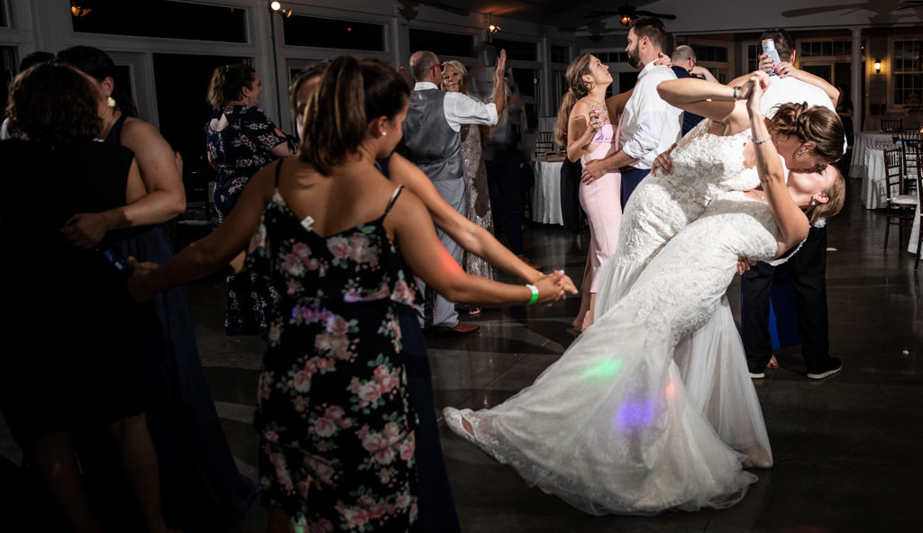 Two brides kissing during the last dance at their wedding reception