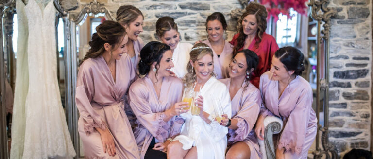 A bride and bridesmaids laughing and having fun. This is for the article called pre-wedding songs for the bride and bridesmaids getting ready. This is the article cover photo