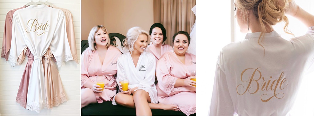 A bride and bridesmaids sitting on a bed wearing silk robes