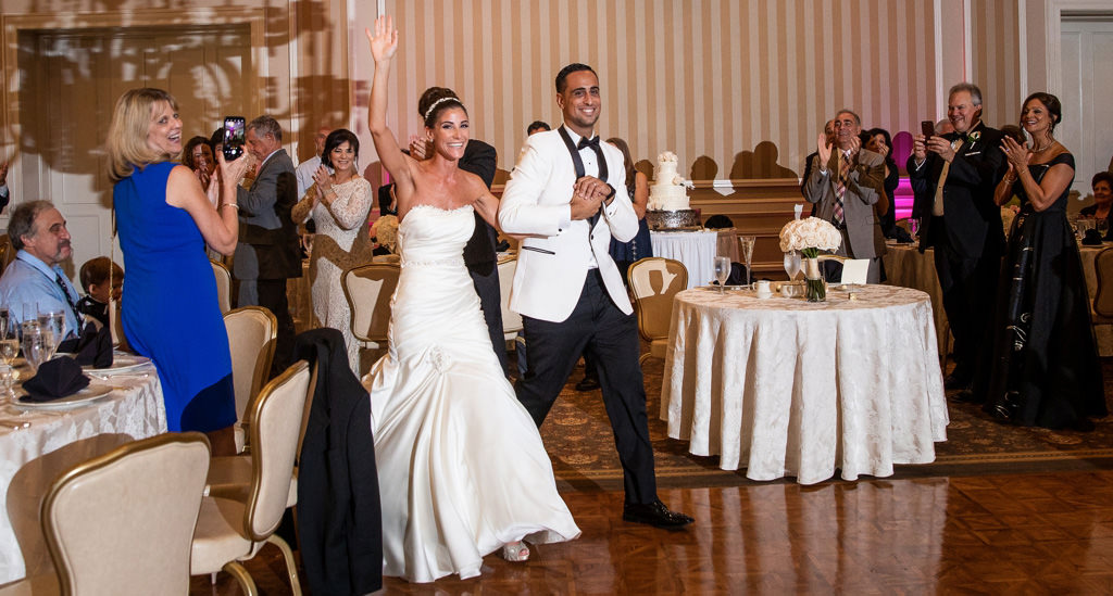 A bride and groom entering their wedding reception