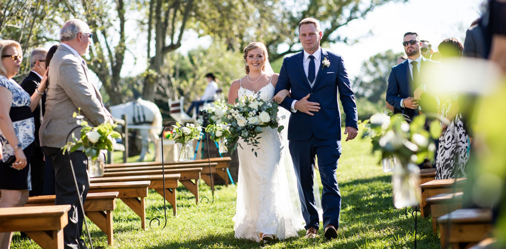 A bride and her dad walking down the aisle to an acoustic song on the wedding day
