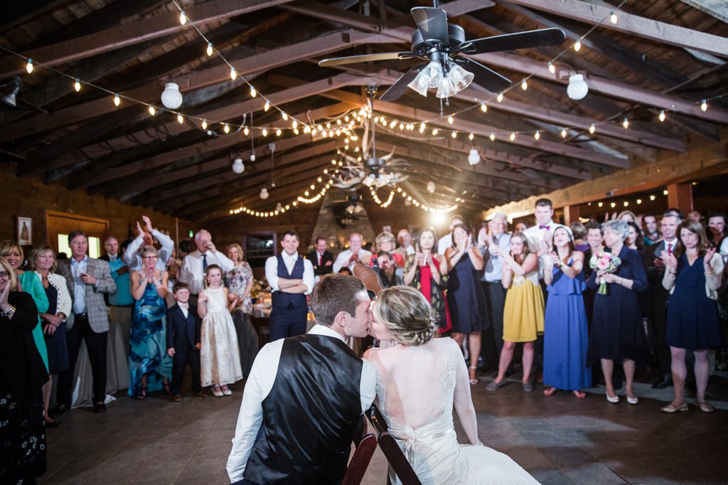 A bride and groom kissing at the end of the show wedding shoe game.