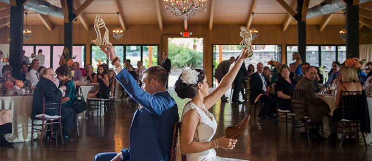 The cover photo for the wedding shoe game article. This shows a bride and groom holding up a show while playing this fun game.