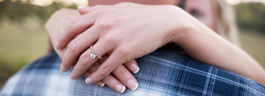A close up photo of a bride showing off her engagement ring. This is for the article called what if my engagement ring is too big.