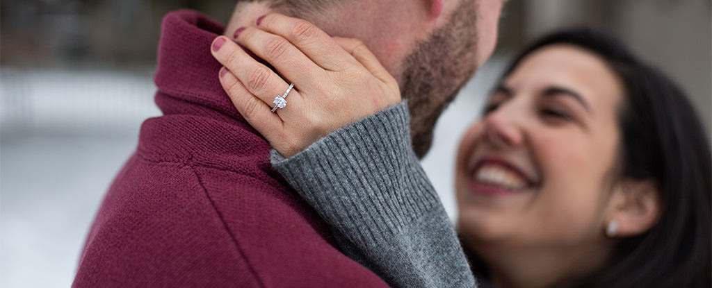 A photo of a bride showing off her new engagement ring. This is for the article called what if my engagement ring is too small.