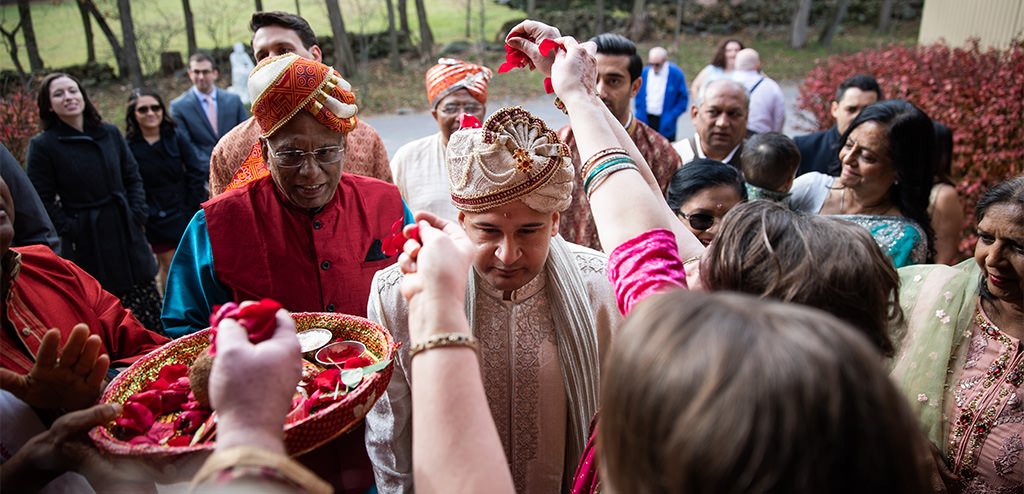 A groom is showered with flower petals during a Hindu wedding ceremony