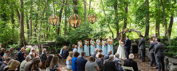 A wedding ceremony outside in the woods. This is the cover photo for the article called questions to ask your wedding venue before you book.