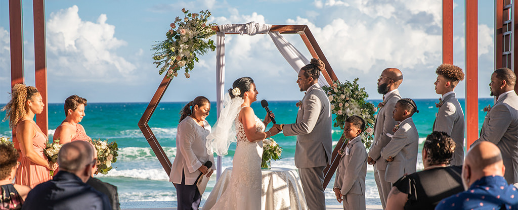 A couple getting married at the beach during their destination wedding.