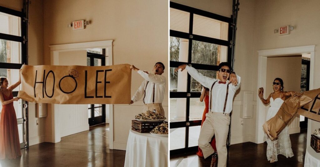 A bride and groom crashing through a paper sign with their names on it as they enter the wedding reception