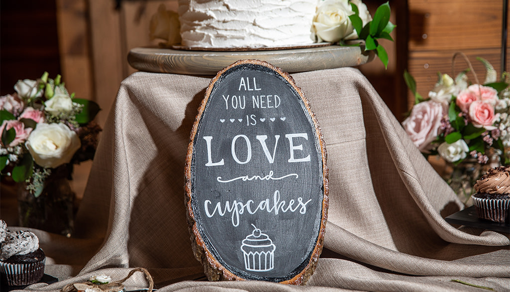 A sign on a dessert that says all you need is love and cupcakes. This is for the article called funny bridal shower cake sayings
