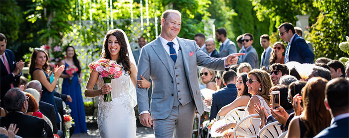 A bride and groom walking down the aisle. This is the cover photo for the article called how to ay for a wedding