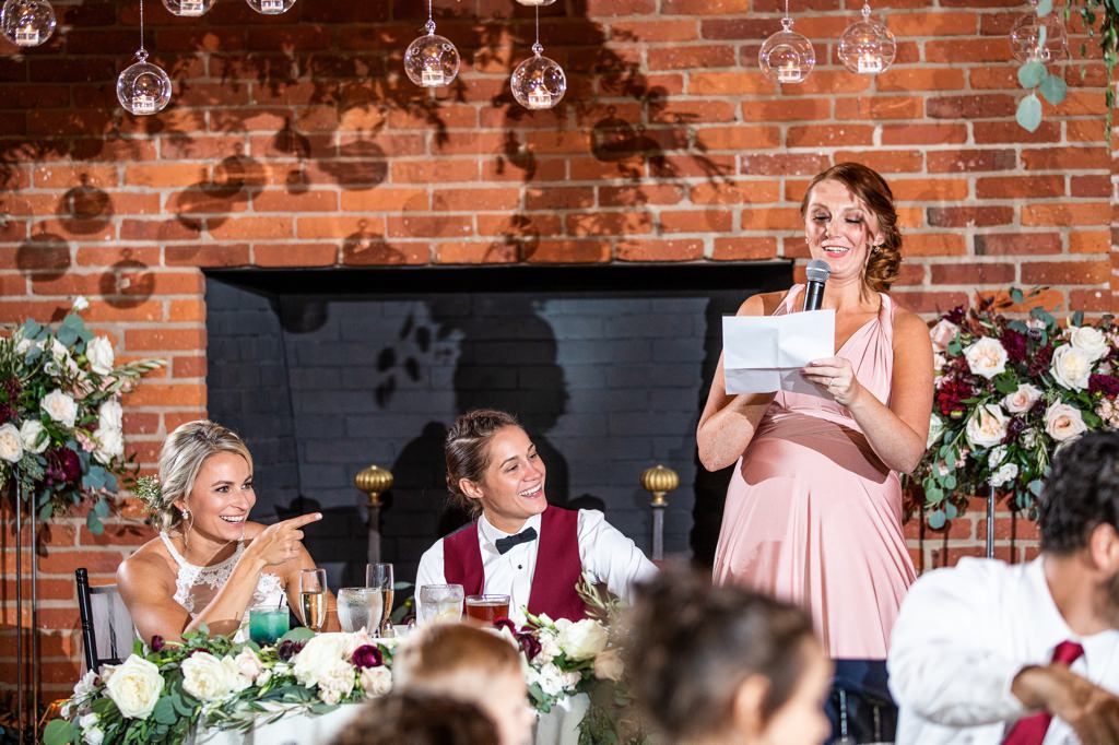 A Maid of Honor is giving a speech to the couple
