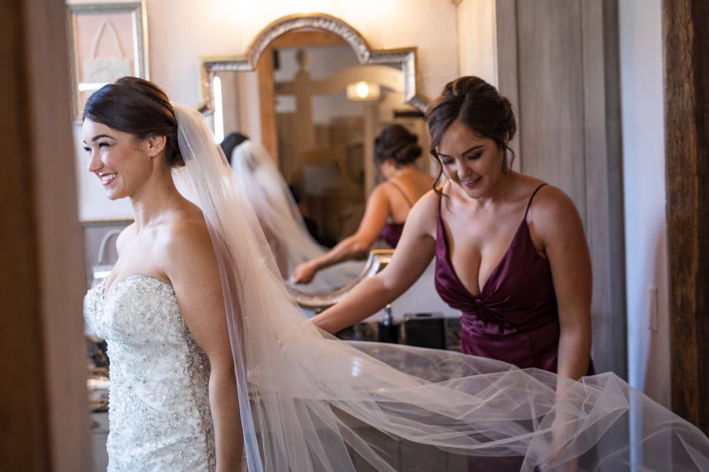 A Matron of Honor fixing the bride's wedding veil.